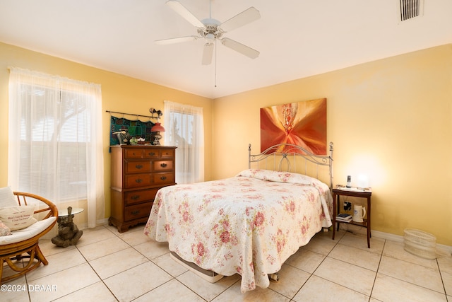 tiled bedroom with multiple windows and ceiling fan