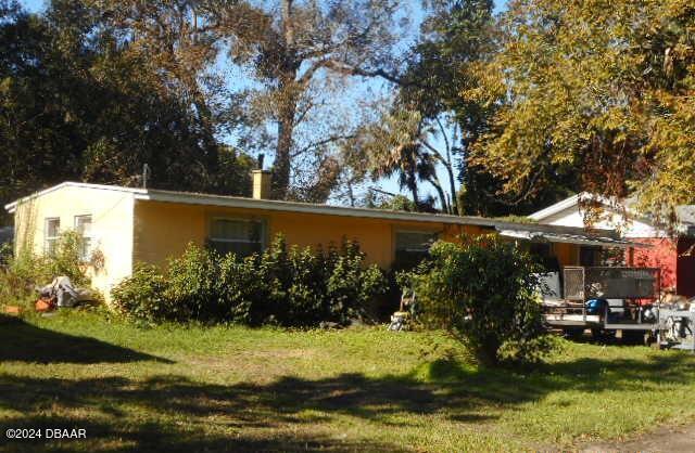 rear view of property featuring a yard