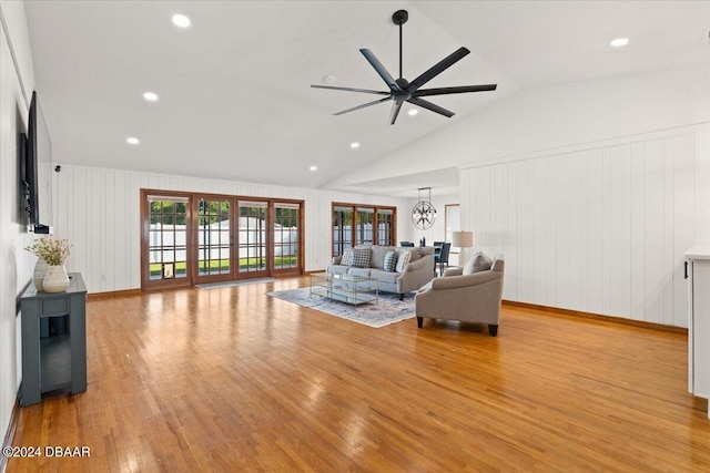 unfurnished living room with french doors, light wood-type flooring, ceiling fan with notable chandelier, and vaulted ceiling