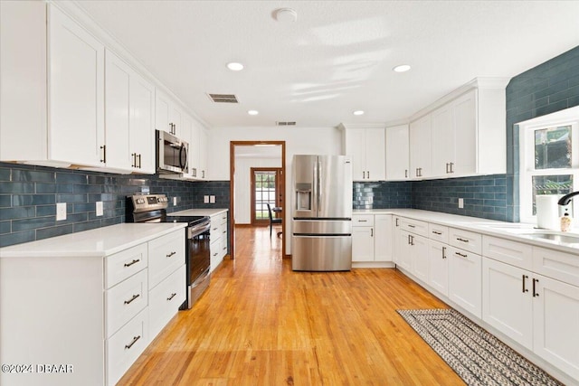 kitchen with white cabinets and appliances with stainless steel finishes