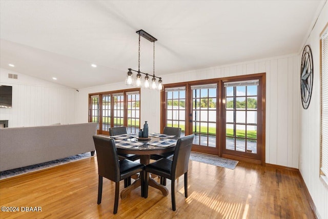 dining area with light wood-type flooring and lofted ceiling