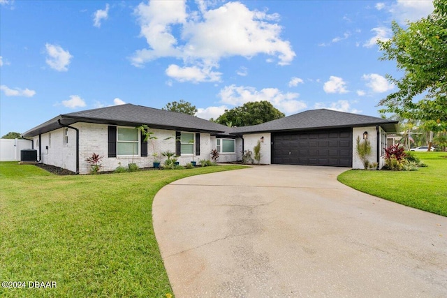 single story home with a front lawn, a garage, and central AC