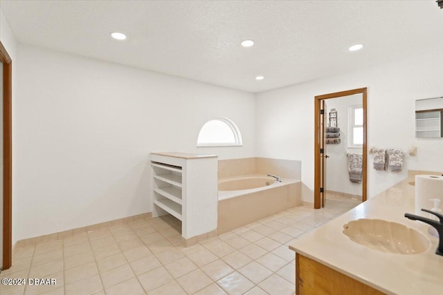 bathroom featuring a bathing tub, tile patterned flooring, vanity, and a textured ceiling