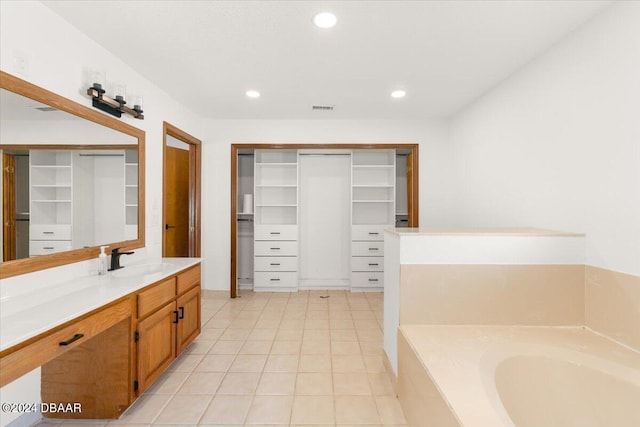 bathroom with a bath, vanity, and tile patterned floors