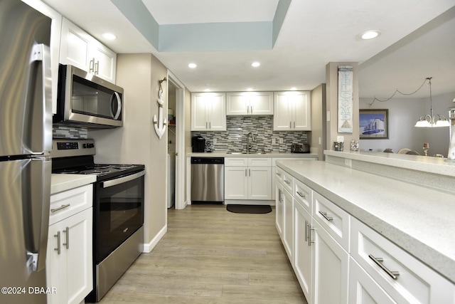 kitchen featuring white cabinetry, pendant lighting, and appliances with stainless steel finishes