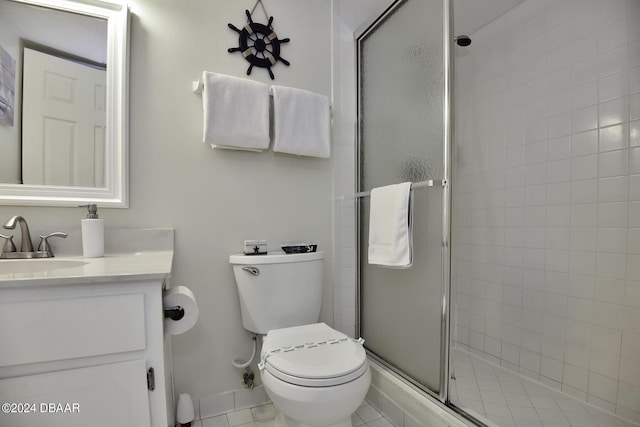 bathroom featuring tile patterned floors, vanity, toilet, and a shower with door