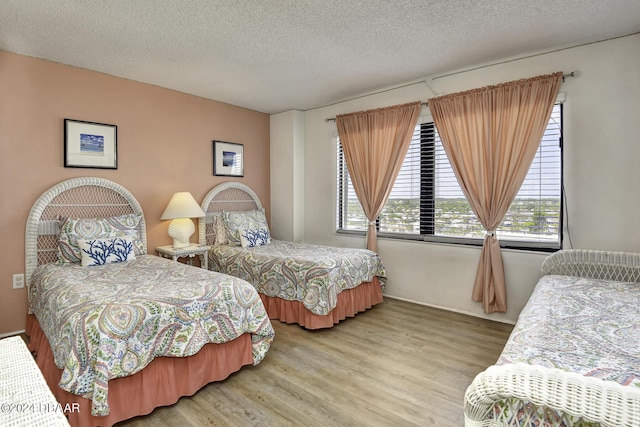 bedroom with hardwood / wood-style floors and a textured ceiling