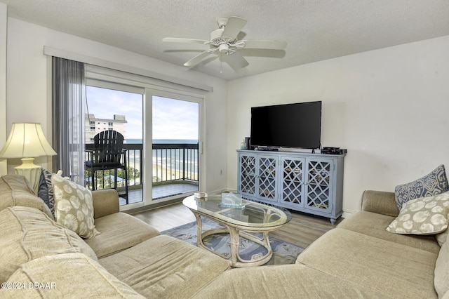 living room featuring hardwood / wood-style floors, a textured ceiling, and ceiling fan