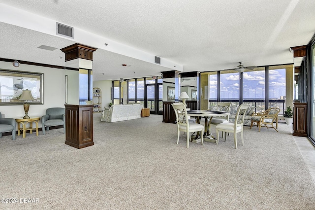 dining room featuring ceiling fan, light carpet, and a wall of windows