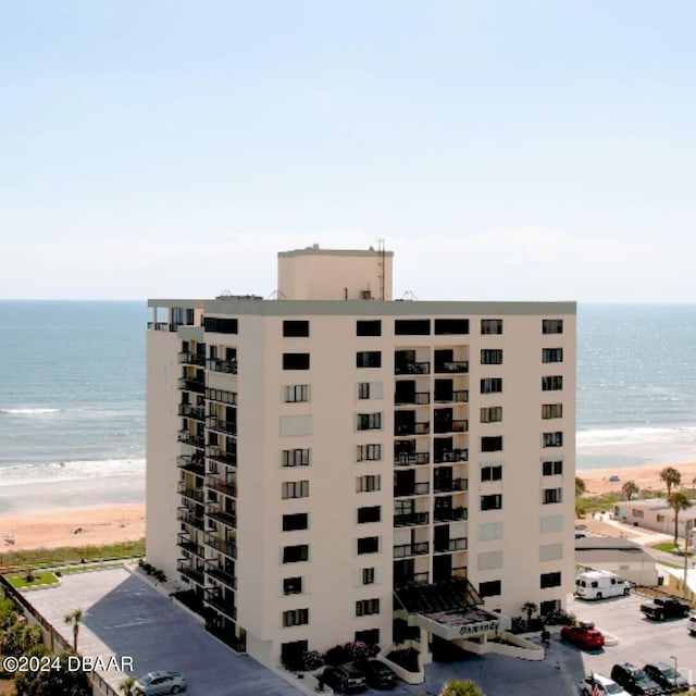 view of building exterior featuring a beach view and a water view