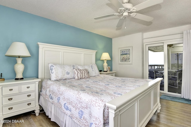 bedroom with access to exterior, ceiling fan, wood-type flooring, and a textured ceiling