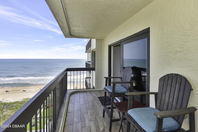 balcony with a water view and a beach view