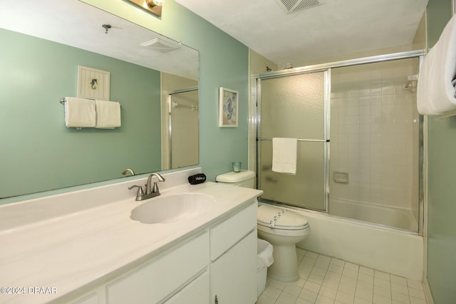 full bathroom featuring tile patterned flooring, vanity, toilet, and combined bath / shower with glass door