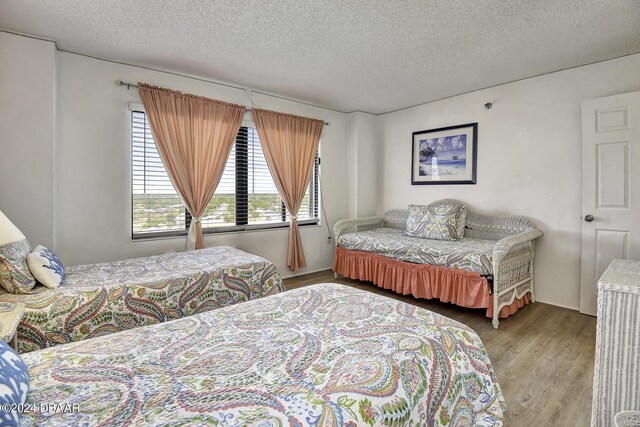 bedroom featuring a textured ceiling and light wood-type flooring