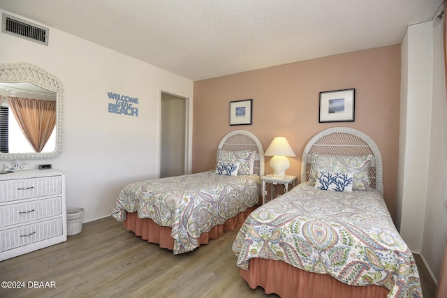 bedroom featuring light hardwood / wood-style floors and a textured ceiling