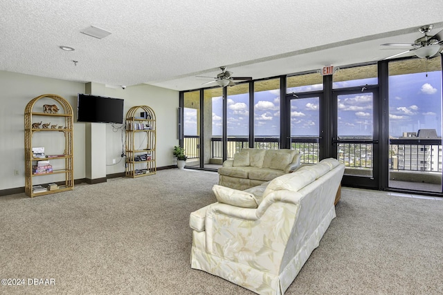 carpeted living room featuring ceiling fan and a textured ceiling