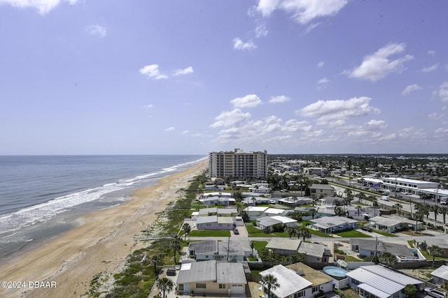 birds eye view of property with a water view and a beach view