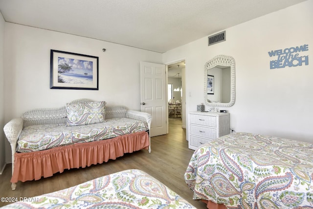 bedroom featuring hardwood / wood-style floors and a textured ceiling