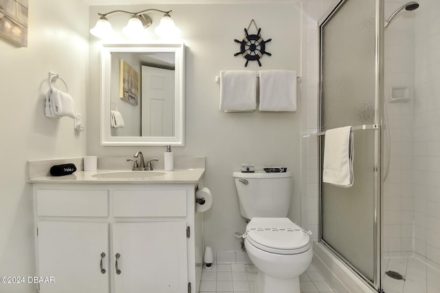 bathroom featuring tile patterned flooring, vanity, a shower with shower door, and toilet