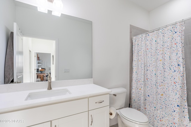 bathroom with toilet, vanity, and walk in shower