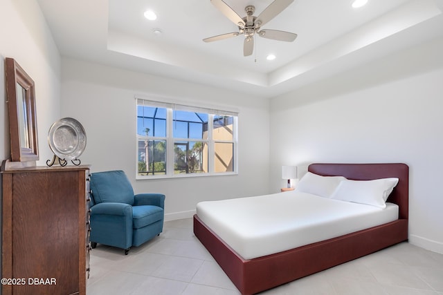 bedroom featuring a raised ceiling, ceiling fan, and light tile patterned flooring