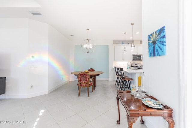 tiled dining room featuring sink and a chandelier