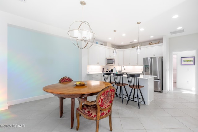 dining space featuring a chandelier, light tile patterned floors, and sink