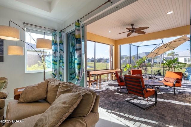 sunroom with ceiling fan and a mountain view