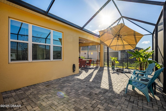 view of patio featuring glass enclosure