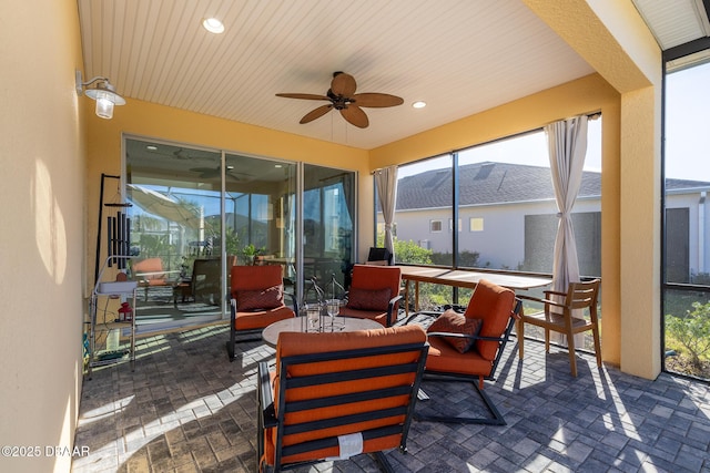 sunroom / solarium featuring ceiling fan