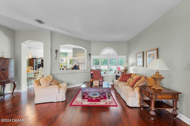 living room with wood-type flooring, a textured ceiling, and an inviting chandelier