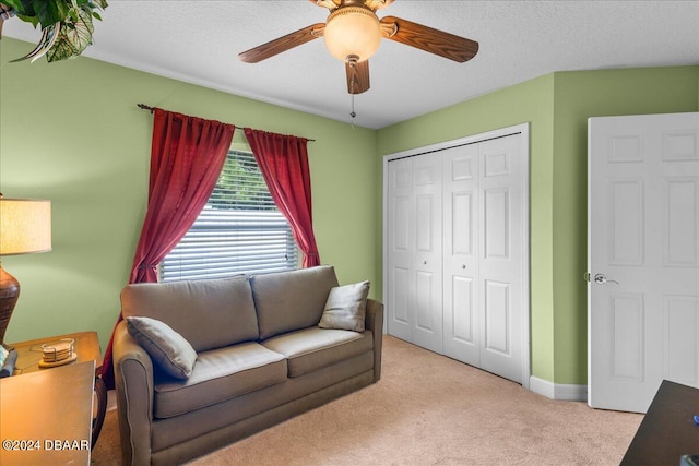 carpeted living room featuring a textured ceiling and ceiling fan