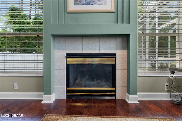 interior details featuring a tiled fireplace and hardwood / wood-style flooring