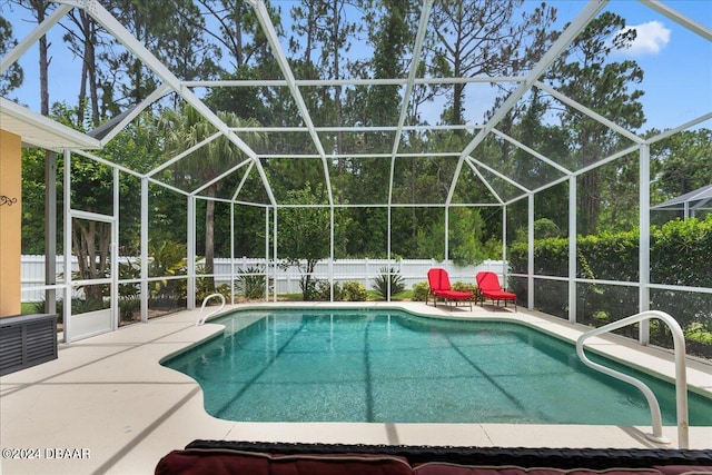 view of pool with glass enclosure and a patio area