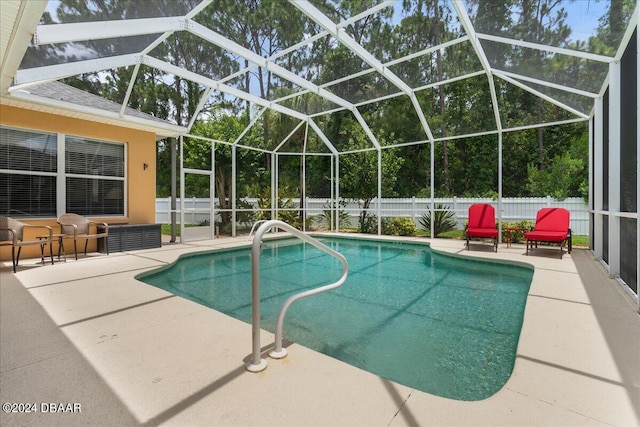 view of swimming pool featuring glass enclosure and a patio area