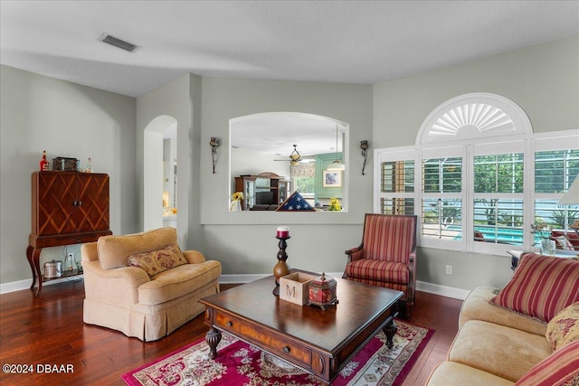 living room featuring dark wood-type flooring and ceiling fan