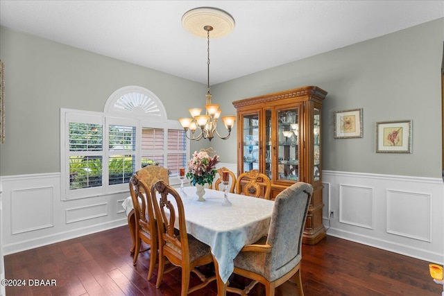 dining area featuring dark hardwood / wood-style flooring and an inviting chandelier