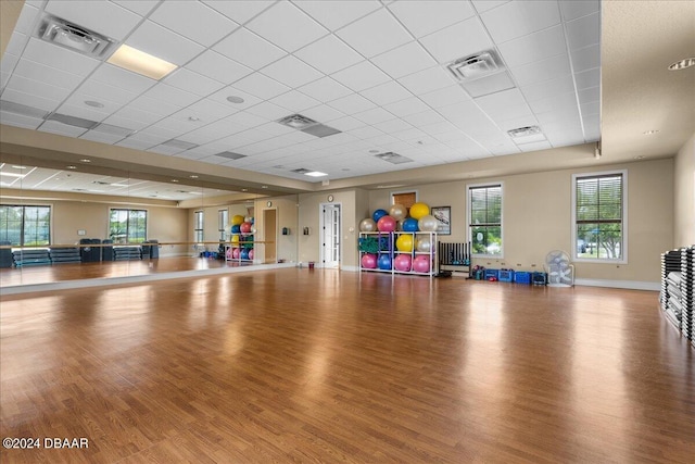 exercise room featuring a paneled ceiling and wood-type flooring