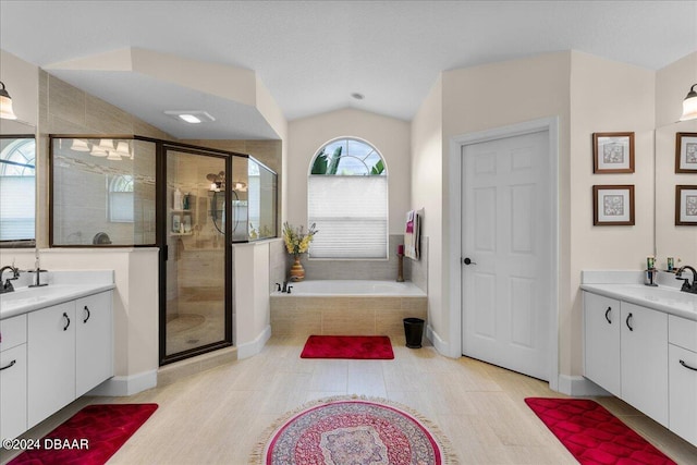 bathroom with shower with separate bathtub, lofted ceiling, and vanity