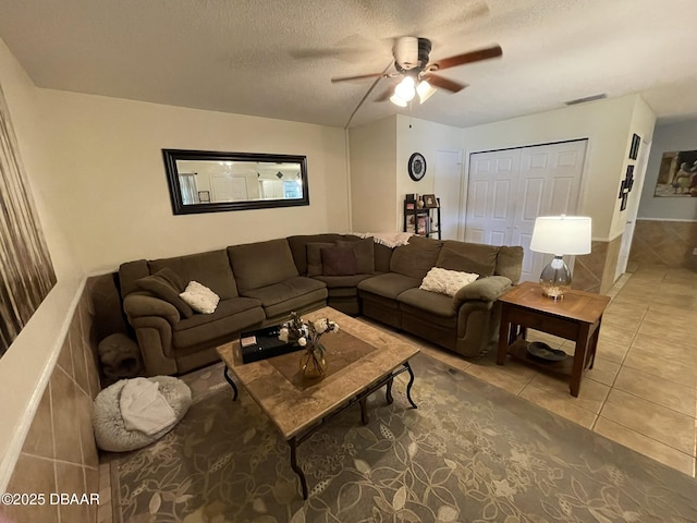 living room featuring ceiling fan, tile patterned floors, and a textured ceiling