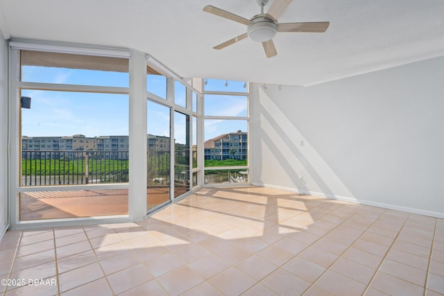 unfurnished sunroom featuring ceiling fan