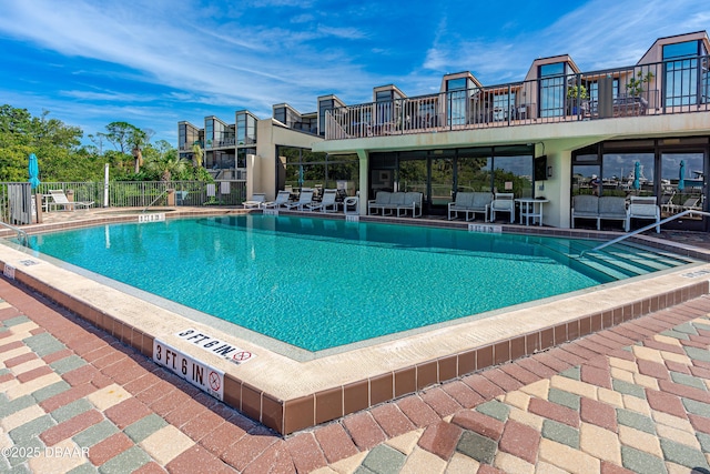 pool with a patio and fence