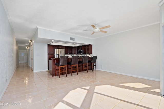 kitchen featuring light tile patterned floors, visible vents, appliances with stainless steel finishes, and a kitchen breakfast bar