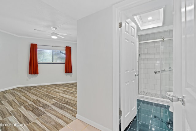 bathroom with a stall shower, baseboards, toilet, ceiling fan, and ornamental molding