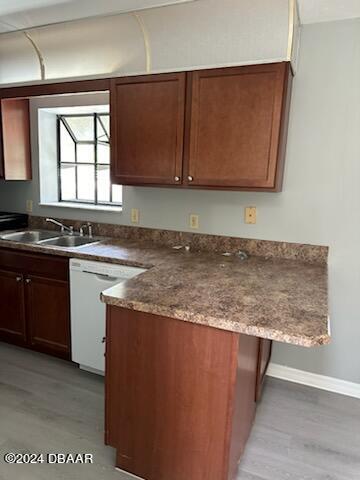 kitchen featuring kitchen peninsula, sink, white dishwasher, and light hardwood / wood-style flooring