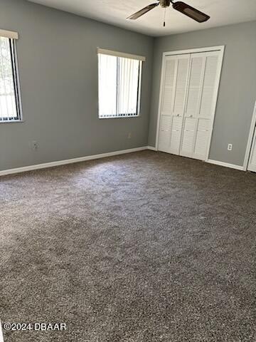 5808 Westport Dr, Port Orange, FL 32127 - unfurnished bedroom featuring a closet, baseboards, ceiling fan, and dark colored carpet
