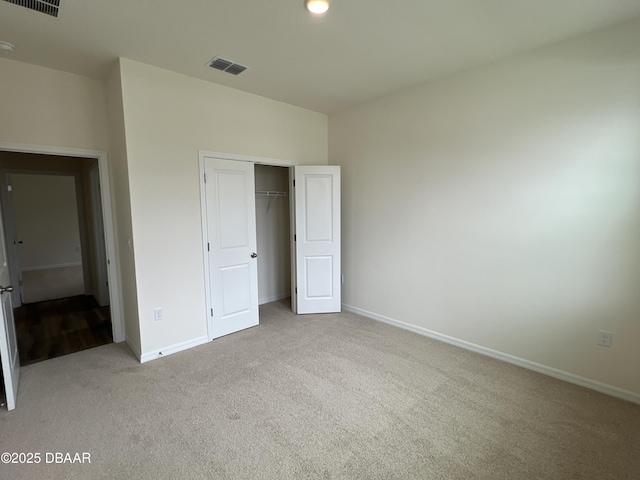 unfurnished bedroom featuring light colored carpet and a closet