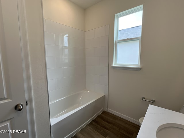 full bathroom featuring washtub / shower combination, hardwood / wood-style floors, toilet, and a healthy amount of sunlight