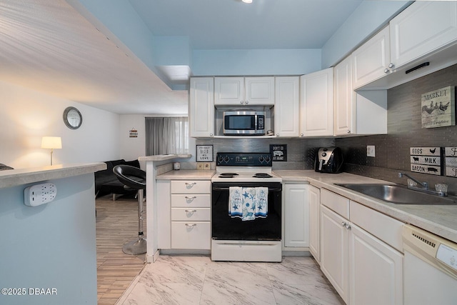 2800 N Atlantic Ave Unit 1105, Daytona Beach, FL 32118 - kitchen with white appliances, white cabinetry, decorative backsplash, and light countertops