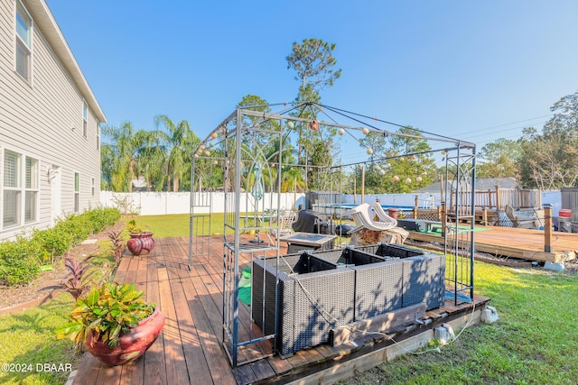 wooden deck with a lawn and a trampoline